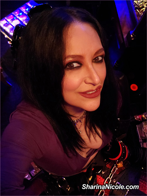 Minneapolis Femdom Dominatrix Sharina Nicole wearing a purple top and looking up at the camera in her bdsm femdom & fetish studio in Minnesota. Mistress. Sharina Nicole is a lifestyle domme & femdom domina from Minneapolis, MN.